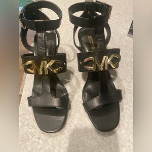 Michael Kors Black Leather T-Strap Heels with Gold MK Plaque